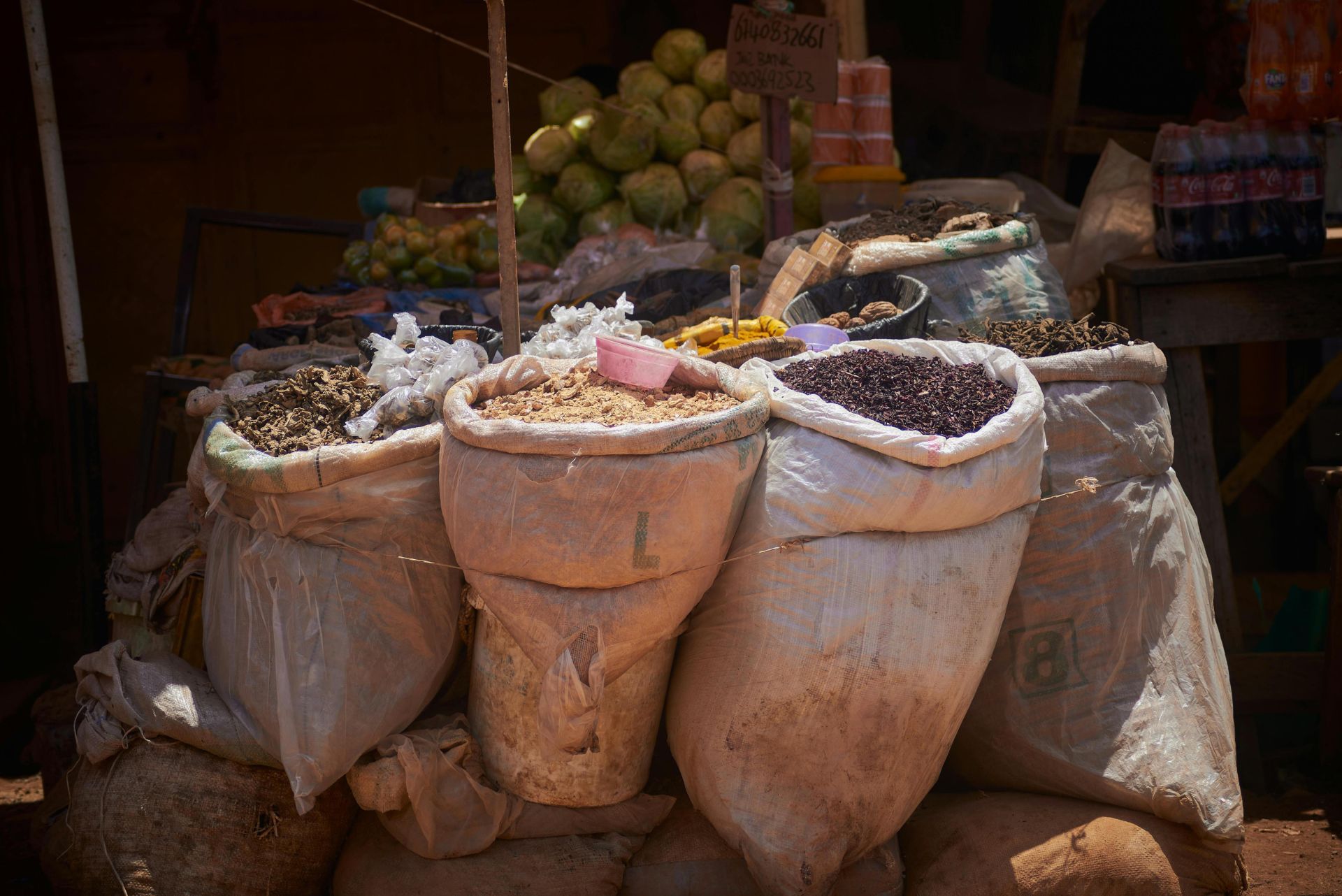 Colorful display of spices and herbs at an outdoor market in Zaria, Nigeria.