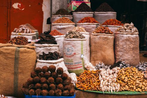 Colorful variety of spices and herbs displayed in a bustling market in Jos, Nigeria.