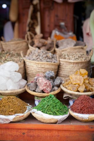 A colorful display of spices and dried goods at a vibrant market stall in Marrakech, Morocco.